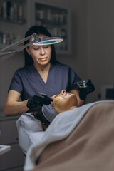 Middle aged woman getting anti aging facial peeling treatment at a cosmetic clinic