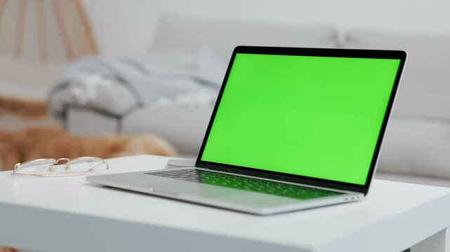 Laptop With Green Mock Up Screen On Table In Home Room Where Dog Walks