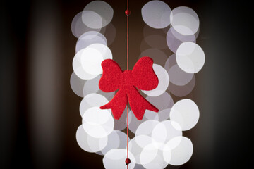 Decorazione natalizia rossa a forma di fiocco con luci sullo sfondo