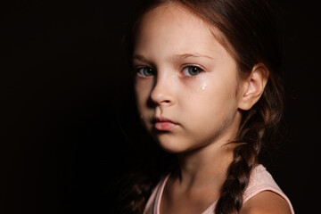 Fototapeta premium Orphanage concept. Sad girl on black background