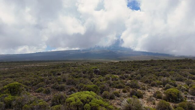 Wide aerial shot of mountain valley and natural area in Tanzania, with mountains in the distance. cinematic aerial shot.