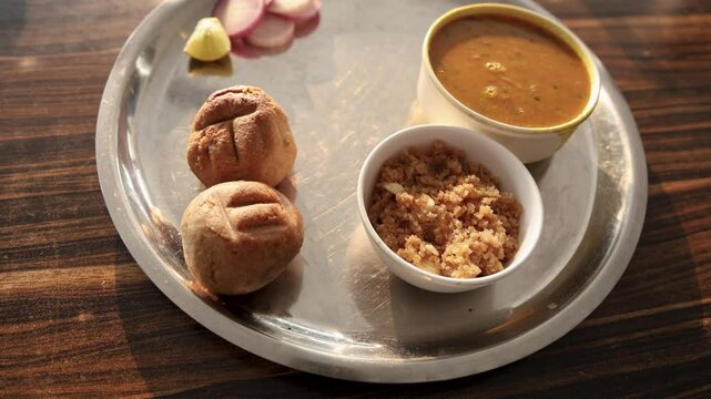 authentic indian traditional food bati served in steel plate from top angle