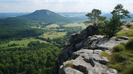 Stunning Panoramic View From a Rocky Ledge Overlooking Lush Green Valleys and Distant Mountains on a Clear Day in Summer