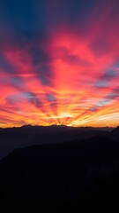 Obraz premium Vivid Sunrise Over a Mountain Range - Vertical Phone Wallpaper Background