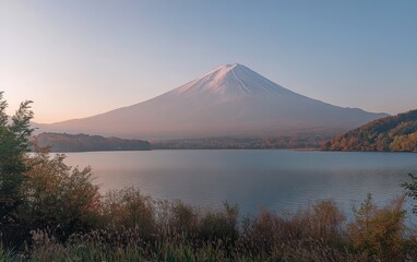 Majestic Mount Fuji Reflected in Tranquil Lake at Sunrise With Clear Skies and Surrounding Greenery in Japan