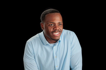 Fototapeta premium Smiling man in light blue shirt against a black background.