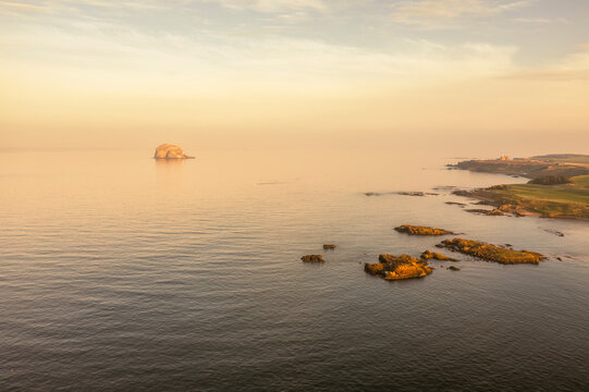 Aerial view of a winter sunset over Bass Rock and Tantallon Castle in North Berwick, Scotland