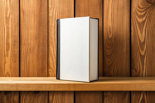 Book on a wooden shelf. On a wooden, white background.