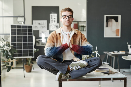 Engineer practicing lotus pose on office desk