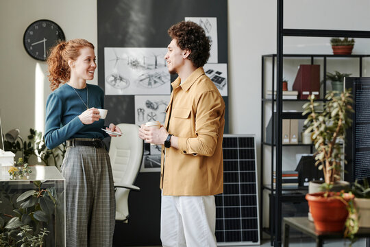 Happy colleagues talking in break at office