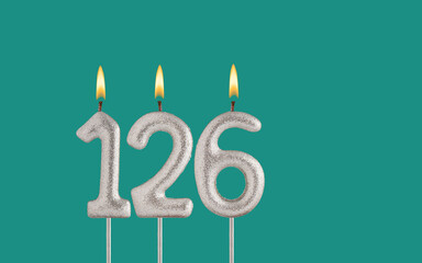 Birthday candle number 126 - Card on a green background.