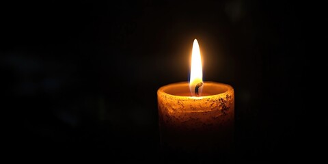 A solitary candle flickering in the darkness, symbolizing hope and serenity.
