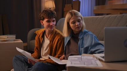 A young man and woman are in the living room discussing a housewarming.