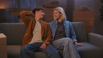 A young man and woman are in the living room discussing a housewarming.