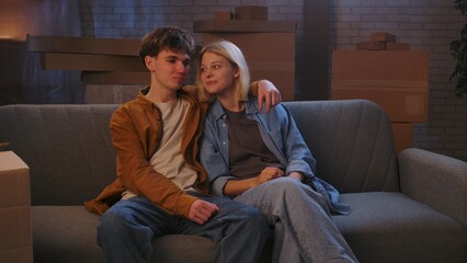A young man and woman are in the living room discussing a housewarming.