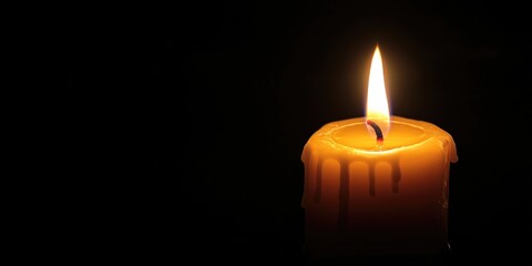 An isolated lit candle on a dark background, glowing with a warm, inviting light.