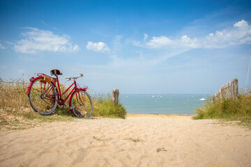 Fototapeta premium Vieux vélo rouge au bords des plages de Bretagne en France.