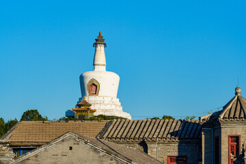 White Pagoda of Beihai Park under blue sky in sunlight in Autumn