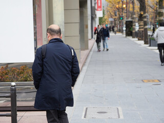 冬の大阪市の繁華街で出勤する中年サラリーマンの姿