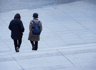 冬の大都市の繁華街で歩く二人の中年女性の姿