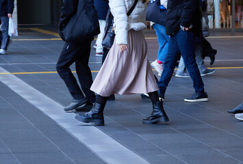 Obraz premium 冬の昼の大阪市の繁華街の大阪駅の広場で歩く人々の姿