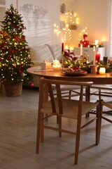 Festive table setting in room decorated for Christmas. Bokeh effect