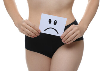 STD (sexually transmitted disease). Woman holding sticky note with drawn sad face on white...