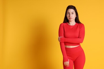Obraz premium Portrait of woman in sportswear on orange background, space for text