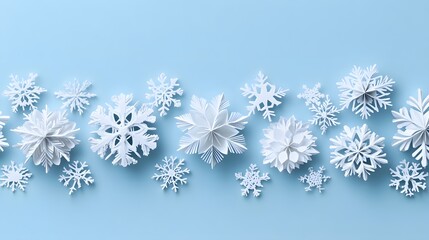 Delicate white paper snowflakes with intricate cutout details arranged in neat rows against a light baby blue background, showcasing minimalist winter decoration with soft drop shadows.