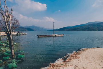 The boat is in the lake and under the blue sky