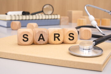 wooden blocks forming the word SARS with a stethoscope in the background.