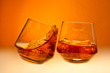 Cheers with two glasses of whisky on the rocks