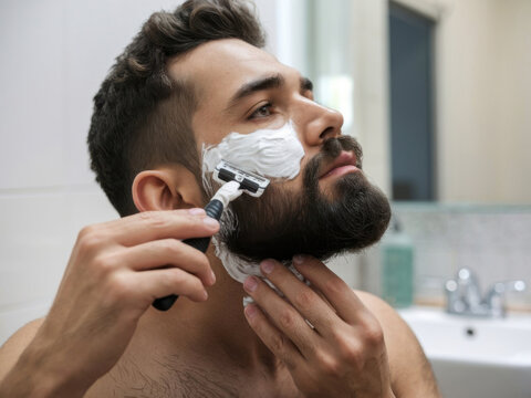 Hombre afeit&aacute;ndose la barba con una navaja
