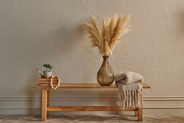 Wooden bank and chair concept, vase of cotton plant, blanket and frame decor, dark yellow wall...