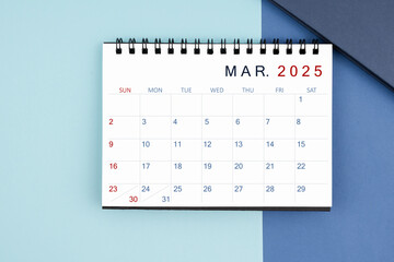 March 2025 monthly desk calendar for 2025 year on blue background.