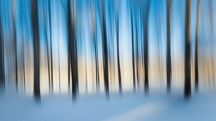 Obraz premium Tranquil forest scene with blurred trees against a serene blue sky and soft snow-covered ground inviting a sense of peace and solitude