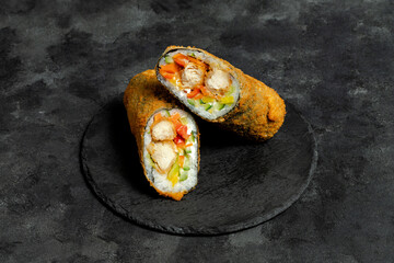 Fried sushi burrito sliced on black plate