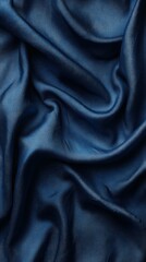 Obraz premium A close-up of luxurious dark blue satin fabric, showcasing its smooth texture and folds.