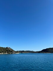 Fototapeta premium Bright blue sky over calm waters on a sunny day near scenic coast