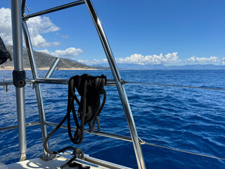 Sailing in clear waters with mountains in the background on a sunny day