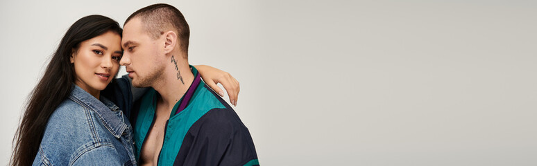 A charming young couple displays their love in a studio setting, dressed in stylish outfits, banner