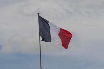 Drapeau tricolore Français sur fond de ciel parisien nuageux