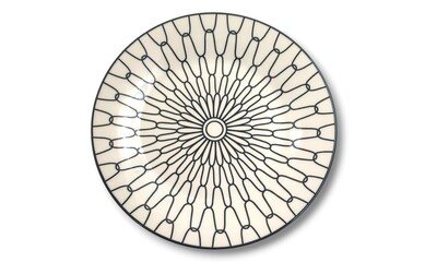 Top view of a white ceramic plate with black geometric sunburst pattern, isolated on white background.