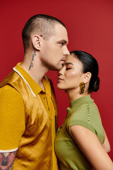 A beautiful young couple poses closely together, celebrating romance in a studio setting.