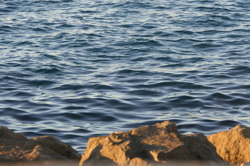 mer au second plan avec une digue de rochers au premier plan