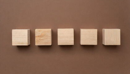 5 wooden cubes on brown surface. Wood blocks. Flat lay. Place for adding text or design.