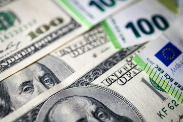100 dollar bills and 100 euro bills close-up symbolize wealth, international finance, currency exchange and world economy, world currency market, competitors