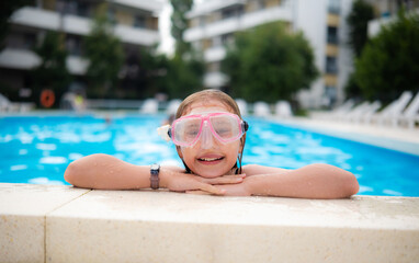 Cute Little Girl Smiling And Wearing A Diving Mask While Swimming In A Hotel Pool