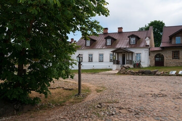 View of historical merchant buildings of estates on the main street of Izborsk Pechorskaya Street on a summer sunny day, Izborsk, Pskov region, Russia
