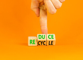 Reduce or recycle symbol. Concept words Reduce Recycle on wooden block. Beautiful orange table orange background. Businessman hand. Business reduce or recycle concept. Copy space.
